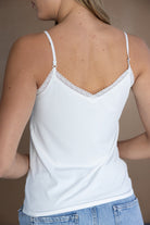 גופיית נשים לבנה עם כתפיות דקות ותחרה עדינה, צילום מאחור, אופנה לנשים צעירות