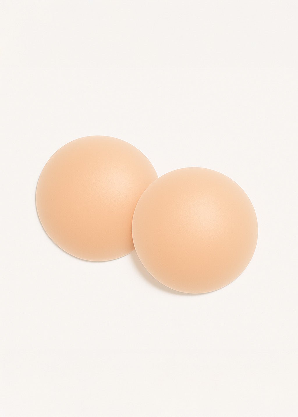 זוג רפידות סיליקון עגולות בצבע גוף, רקע לבן, אביזר אופנה לנשים