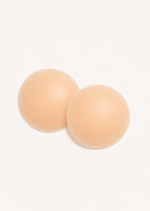 זוג רפידות סיליקון עגולות בצבע גוף, רקע לבן, אביזר אופנה לנשים