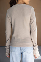 חולצה ארוכה לנשים בצבע בז' עם שרוולים ארוכים, משולבת עם ג'ינס בהיר, צילום מאחור