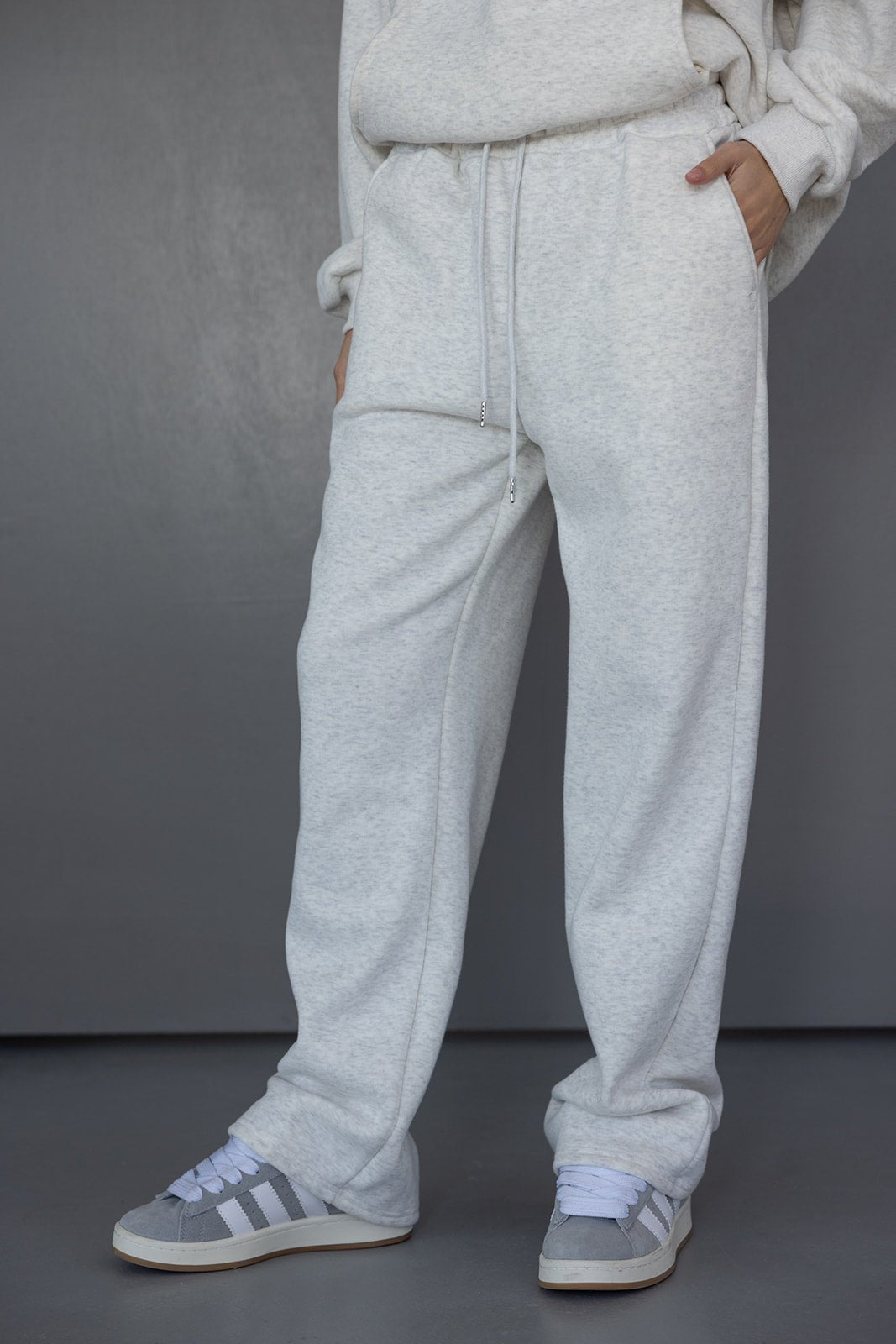 מכנסי טרנינג לנשים בגזרה רחבה בצבע אפור בהיר, נעלי סניקרס אפורות, אופנה יומיומית