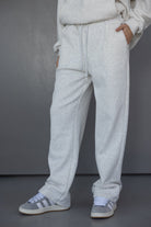 מכנסי טרנינג לנשים בגזרה רחבה בצבע אפור בהיר, נעלי סניקרס אפורות, אופנה יומיומית