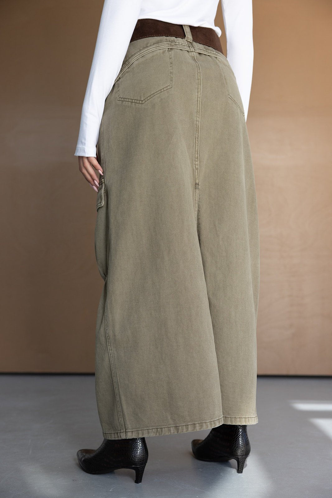 מכנסיים רחבים בצבע חאקי לנשים, בד דנים, חגורה חומה, חולצה לבנה ונעלי עקב שחורות