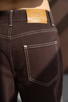 ג׳ינס נשים חום עם תפרים לבנים ותווית עור על המותן, אופנה לנשים צעירות