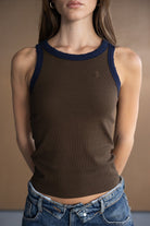 דוגמנית לובשת גופיית ריפ טופ חומה עם שוליים כחולים ומכנסי ג'ינס, אופנת נשים קז'ואל