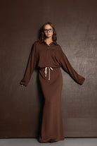 אישה עם שמלת ספורט חומה ארוכה עם שרוכים, בגדי אופנה לנשים, טרנד חורף 2024