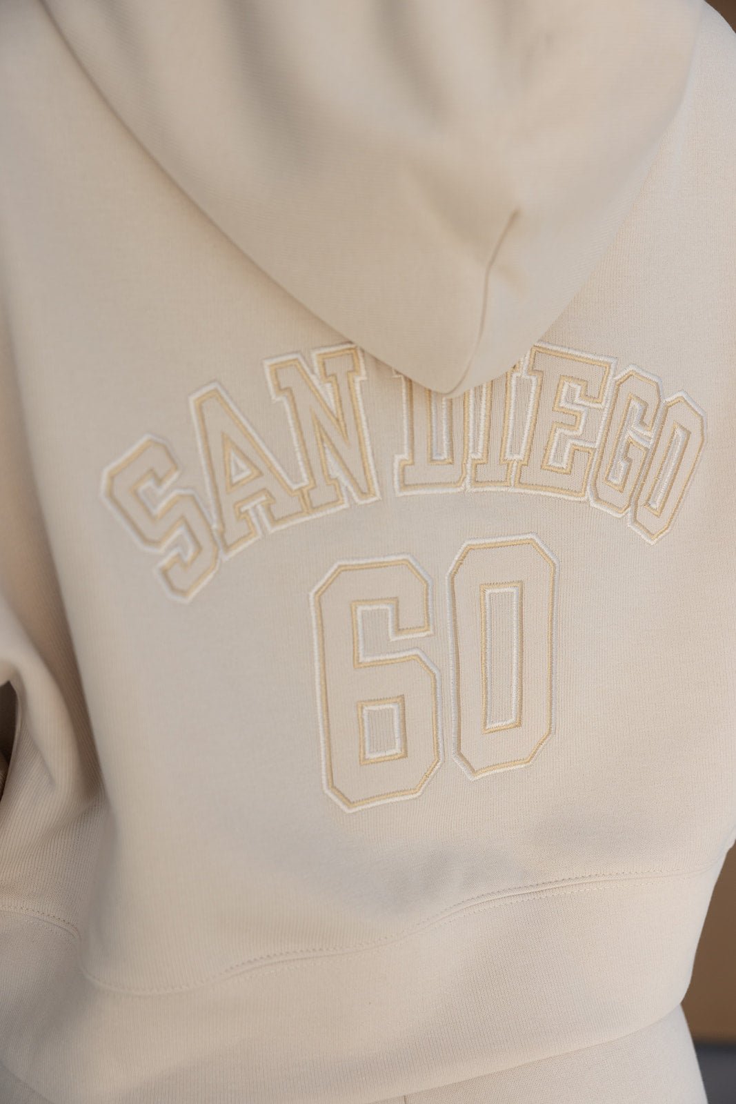 קפוצ'ון אופנתי לנשים בצבע בז', כיתוב SAN DIEGO ומספר 60 בגב, טרנד בגדי נשים