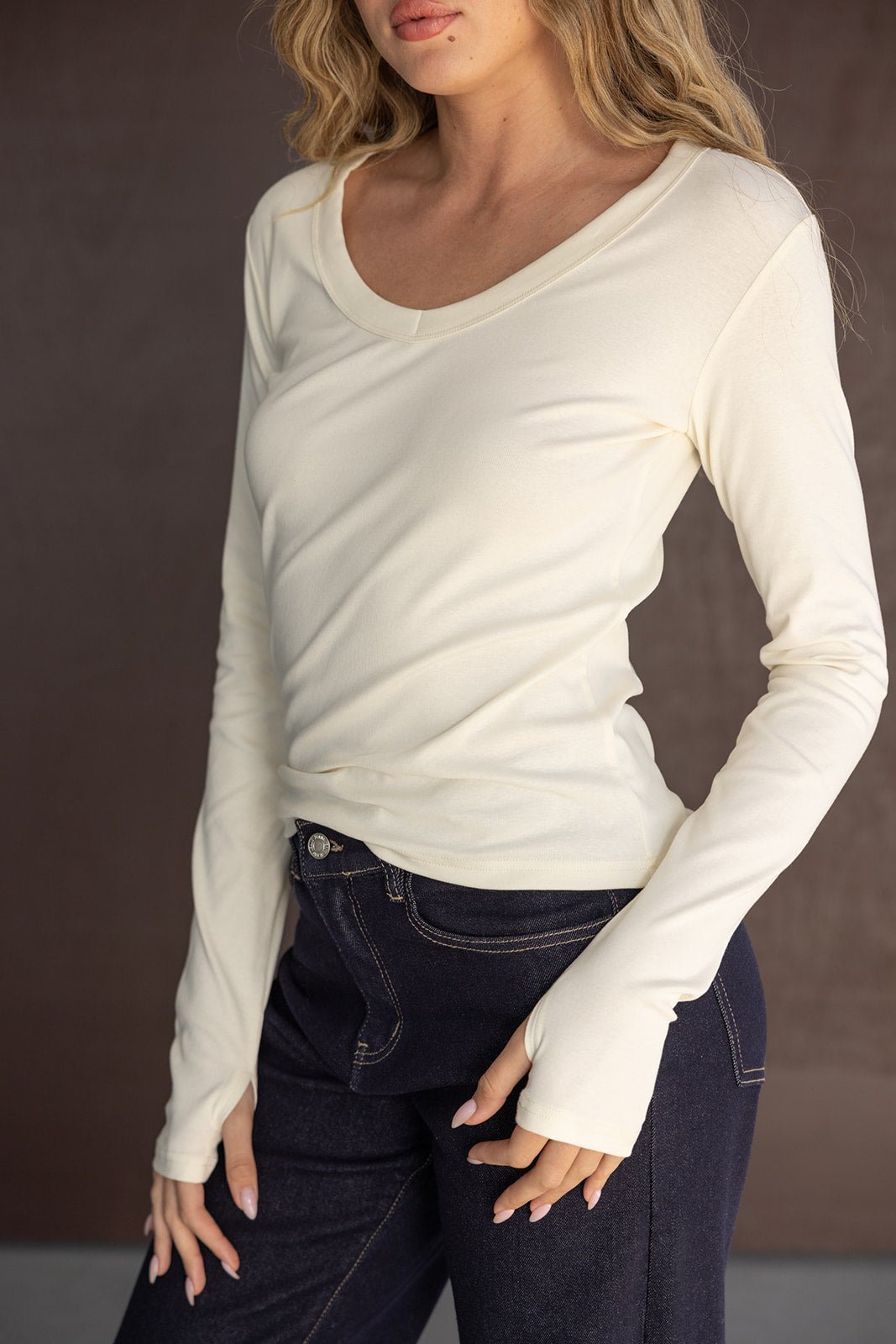 חולצת שרוול ארוך בצבע שמנת לנשים, עם גזרה צמודה, משולבת עם מכנס ג'ינס כהה