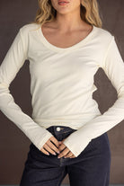 חולצת נשים ארוכה בצבע שמנת עם מחשוף עגול, משולבת עם ג'ינס כהה