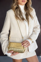 אישה עם בלייזר בהיר, סוודר לבן ותיק צד קלוע מזהב, אופנה לנשים