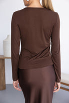 חולצת נשים ארוכה חומה עם חצאית מבריקה חומה, מבט גב, אופנה לנשים צעירות