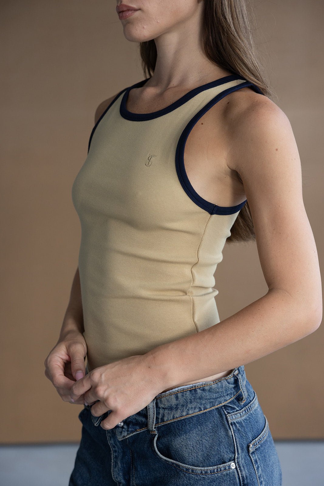 גופיית נשים בצבע בז' עם שוליים כחולים כהים, ג'ינס קז'ואל אופנתי