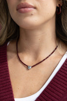 שרשרת חרוזים בורדו עם תליון לב כסוף על צוואר של אישה, אופנה לנשים