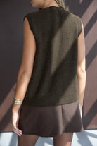 אישה עם גופיית סריג חומה וחצאית מיני חומה, אופנת נשים צעירה ומודרנית