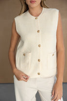 וסט נשים סרוג ללא שרוולים בצבע שמנת עם כפתורים זהובים וכיסים, אופנת חורף לנערות