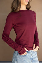 חולצת נשים ארוכה בורדו עם שרוולים ארוכים, משולבת עם ג'ינס בהיר, אופנה לנשים צעירות