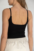 גופיית נשים שחורה עם כתפיות דקות, גב פתוח, בשילוב מכנס לבן קייצי