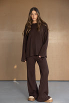 דוגמנית לובשת סט טרנינג חום רחב מבד ריב אופנתי לנשים ונערות, על רקע סטודיו ניטרלי