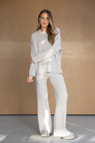 דוגמנית לובשת סט טריקו מחמם בצבע שמנת, חולצה עם שרוולים ארוכים ומכנסיים רחבים, אופנת נשים חורף