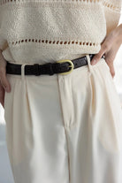 מכנסי נשים בצבע שמנת עם חגורה שחורה, חולצת קרושה בהירה, אופנה קיץ אלגנטית