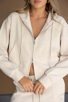 דוגמנית לובשת סט טרנינג נשים בצבע שמנת עם קפוצ'ון וריצ'רץ', אופנת רחוב לנשים