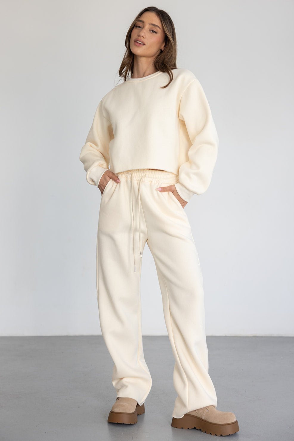 דוגמנית לובשת סט טרנינג נשים בצבע שמנת עם נעליים חומות, אופנה קז'ואל לנשים