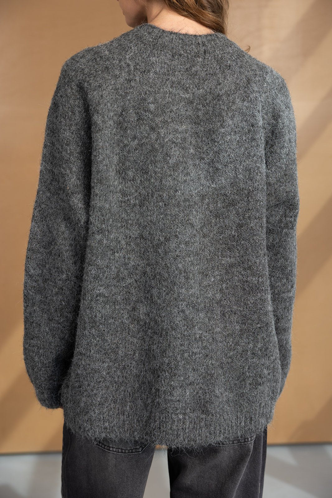 סוודר נשים אפור צמר רך, מראה אחורי, לבוש עם מכנסיים כהים, אופנת חורף לנשים