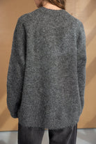 סוודר נשים אפור צמר רך, מראה אחורי, לבוש עם מכנסיים כהים, אופנת חורף לנשים