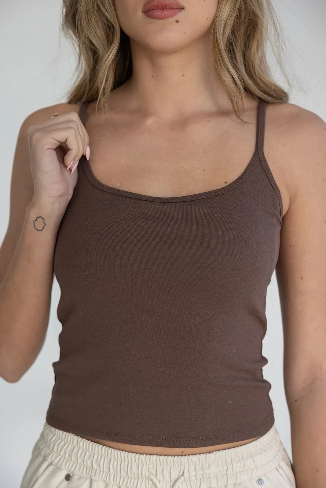 גופיית נשים חומה מחמיאה עם כתפיות ספגטי, לבוש עם מכנסיים בגוון שמנת, אופנה לנשים