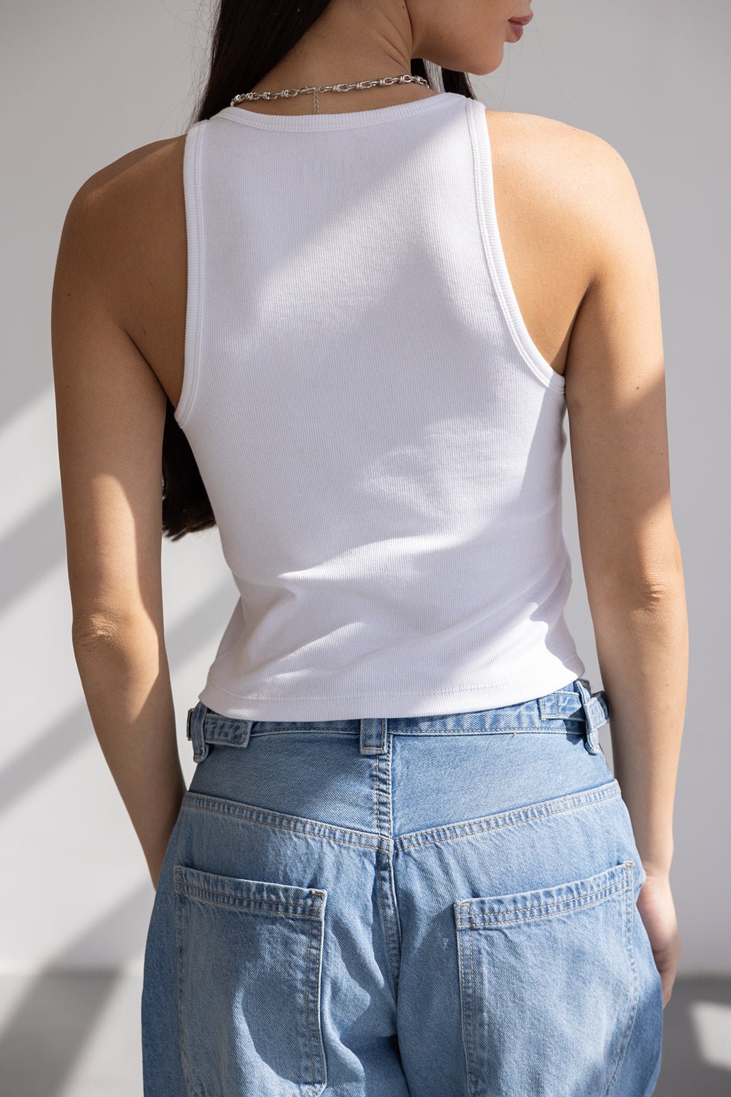 טופ גופייה לבנה לנשים עם גב חשוף בשילוב ג'ינס כחול, אופנה צעירה ועדכנית