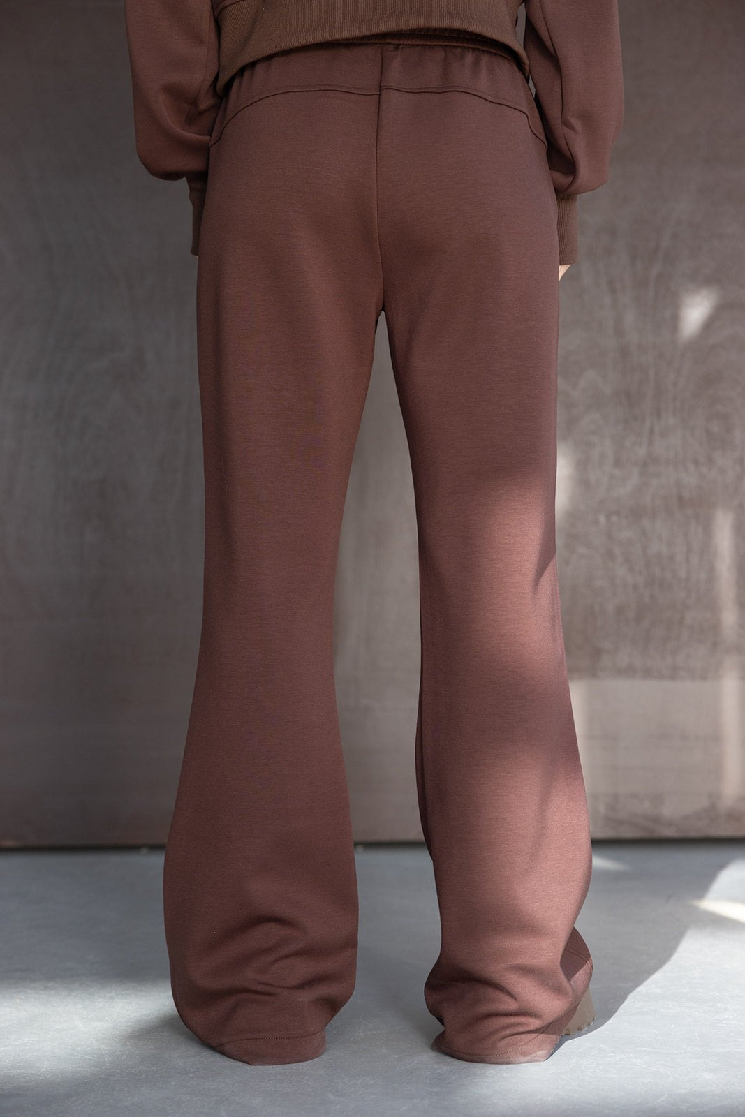 מכנסי טרנינג חומים רחבים לנשים, בד רך ונעים, צילום סטודיו בגדי אופנה עדכנית