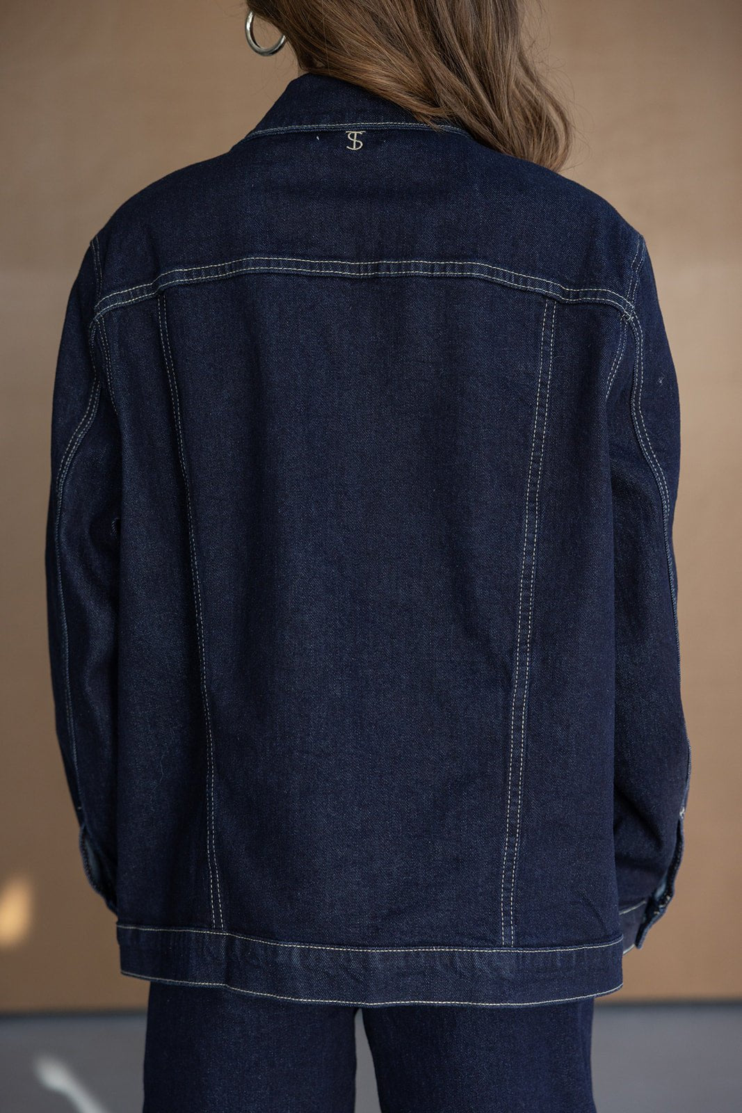 מעיל ג'ינס כהה לנשים, צילום מאחור, עיצוב קלאסי עם תפרים בולטים