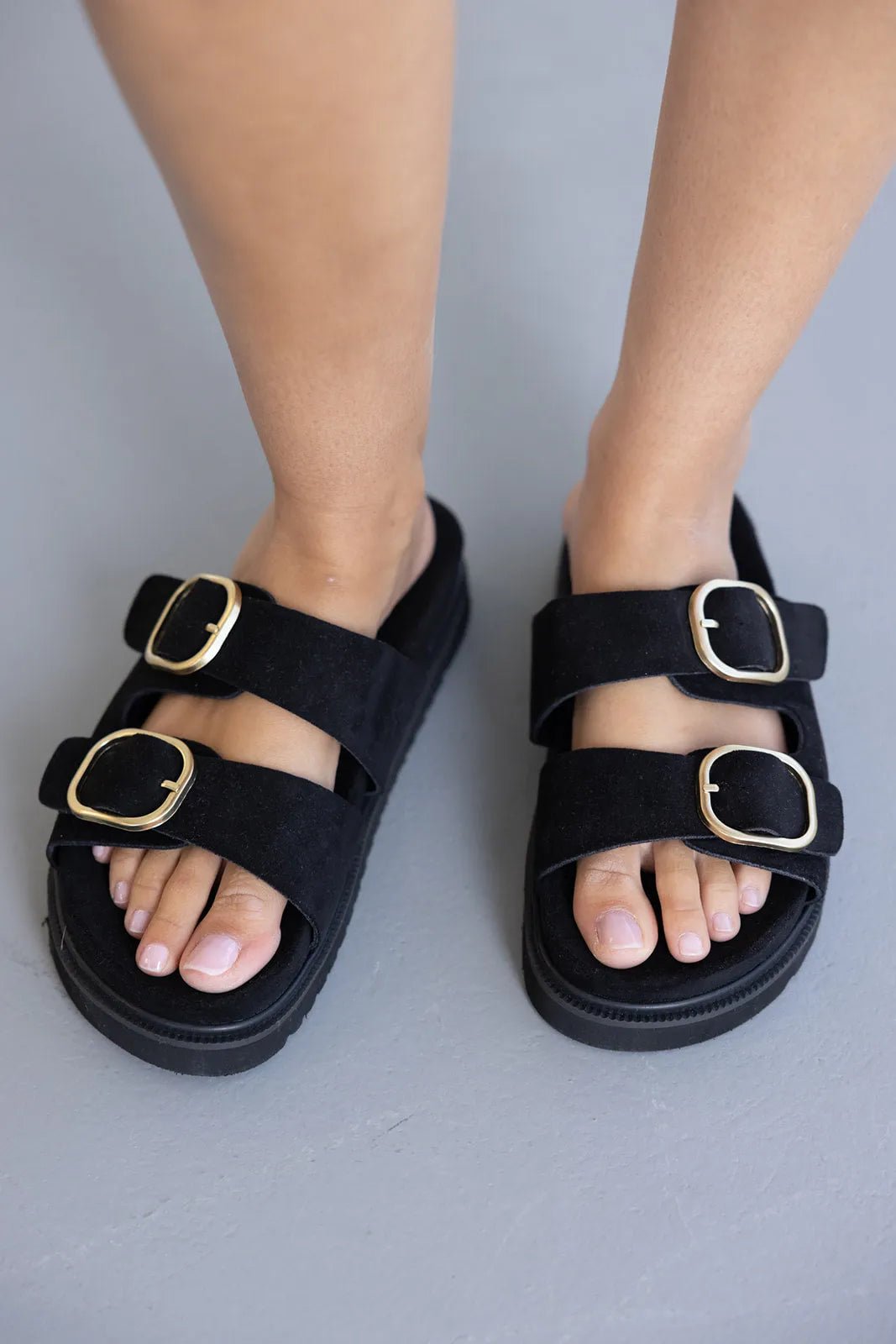 סנדלים שטוחים לנשים בצבע שחור עם שתי רצועות אבזמים זהובים, אופנת קיץ.