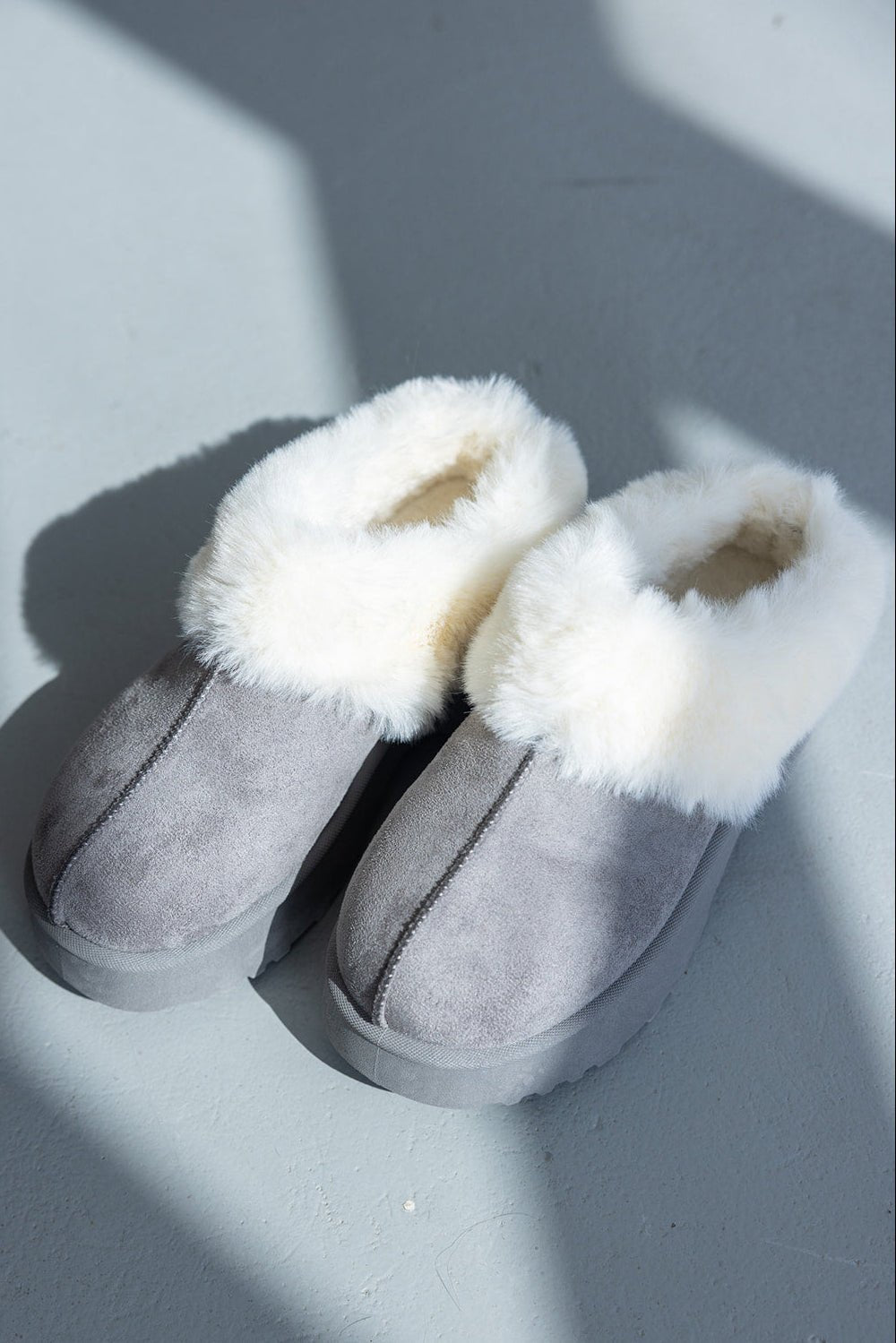 נעלי בית נשים אפור עם פרווה לבנה, נעלי חורף חמות ונוחות על רצפה אפורה