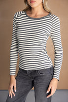 דוגמנית לובשת חולצת פסים ארוכה בצבעי שחור ולבן עם ג'ינס בגזרה גבוהה, אופנה לנשים