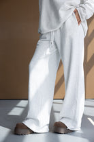 מכנסי טרנינג נשים רחבים אפור בהיר עם חולצה תואמת ונעלי פלטפורמה חומות, לוק אופנתי ונינוח indoors