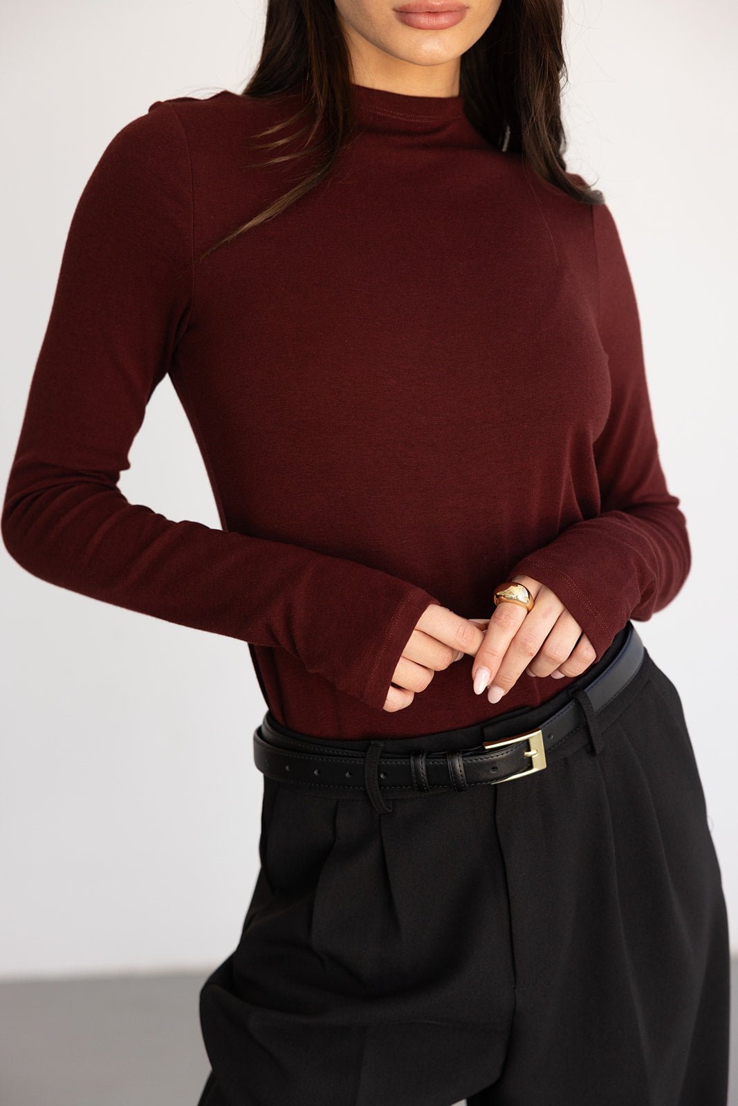 חולצת בייסיק בורדו עם שרוולים ארוכים לנשים, משולבת במכנסיים שחורים חגורה