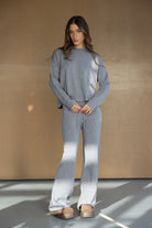 דוגמנית לובשת סט טרנינג אפור לנשים, חולצה ארוכה ומכנס מחמיא, נעלי בית חורפיות