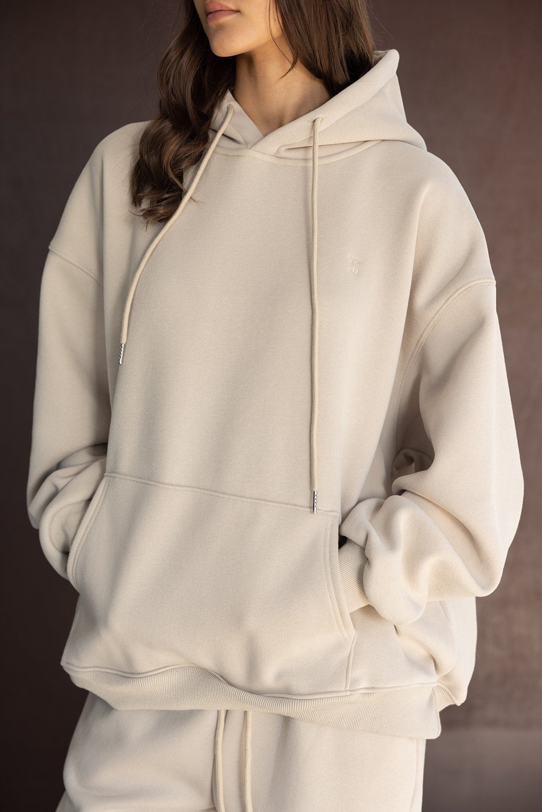 צעירה בלבוש אופנתי, סווטשירט קפוצ'ון בז' לנשים, צילום אופנה חורפי