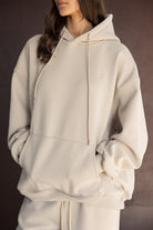 צעירה בלבוש אופנתי, סווטשירט קפוצ'ון בז' לנשים, צילום אופנה חורפי