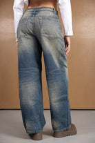 ג'ינס בגזרה רחבה לנשים, צבע תכלת דהוי, שני כיסים אחוריים, חולצת קרופ לבנה ונעליים חומות