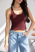 דוגמנית לובשת טופ בורדו גזורה ומכנסי ג׳ינס בגזרה גבוהה, אופנת קיץ לנערות