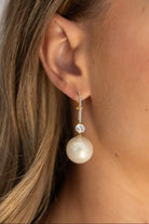 עגיל זהב תלוי משובץ קוביות זירקוניה עם תליון פנינה לאישה, תקריב על האוזן