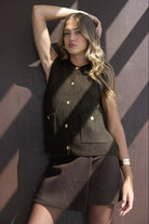 דוגמנית לובשת אפוד סרוג חום ללא שרוולים עם כפתורים וכיסים, חצאית חומה, אופנת נשים קיץ