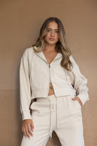 דוגמנית לובשת סט טרנינג אופנתי לנשים בצבע שמנת, הכולל קפוצ׳ון ורוכסן